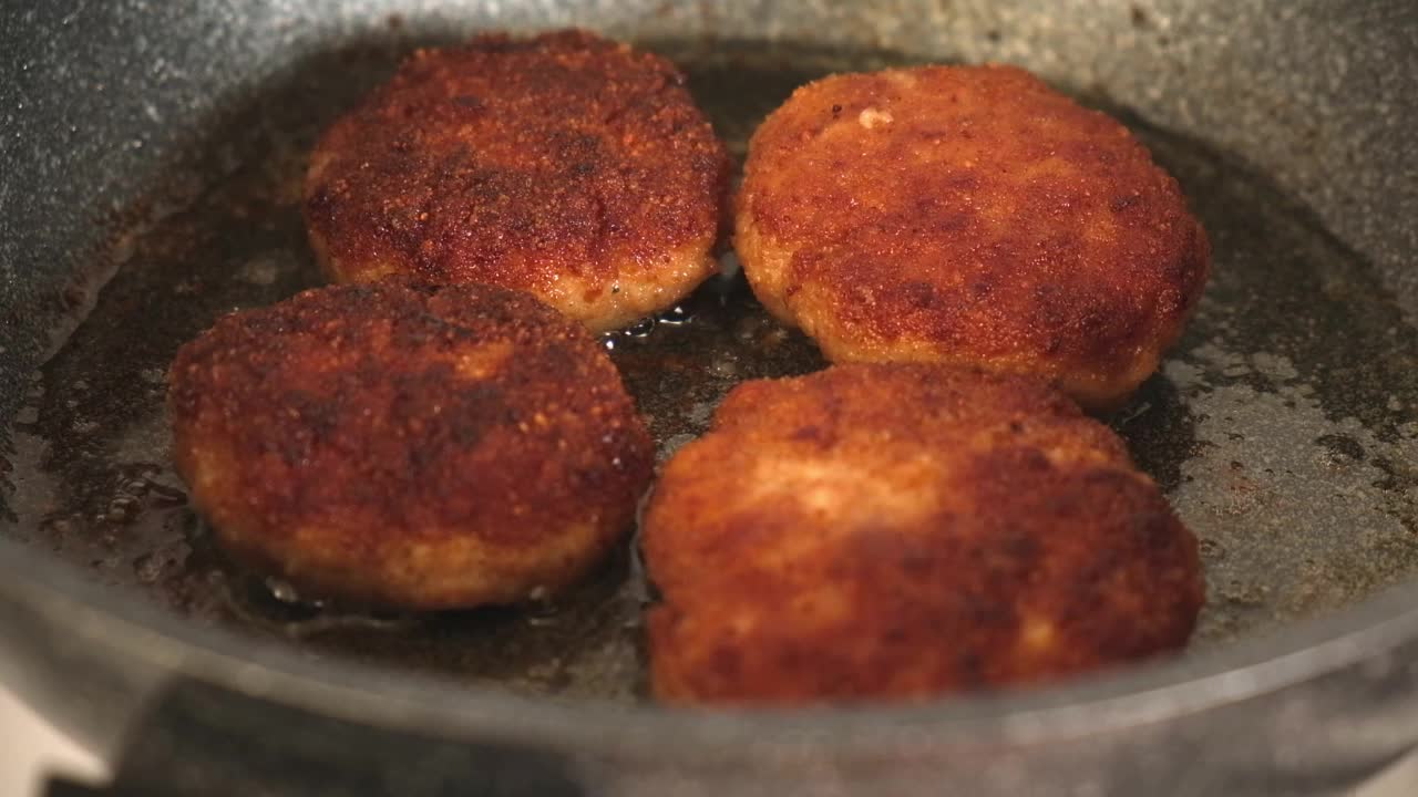 葵花籽油在煎锅里煮，配上自制肉饼。肉排在煎锅里煎。视频素材