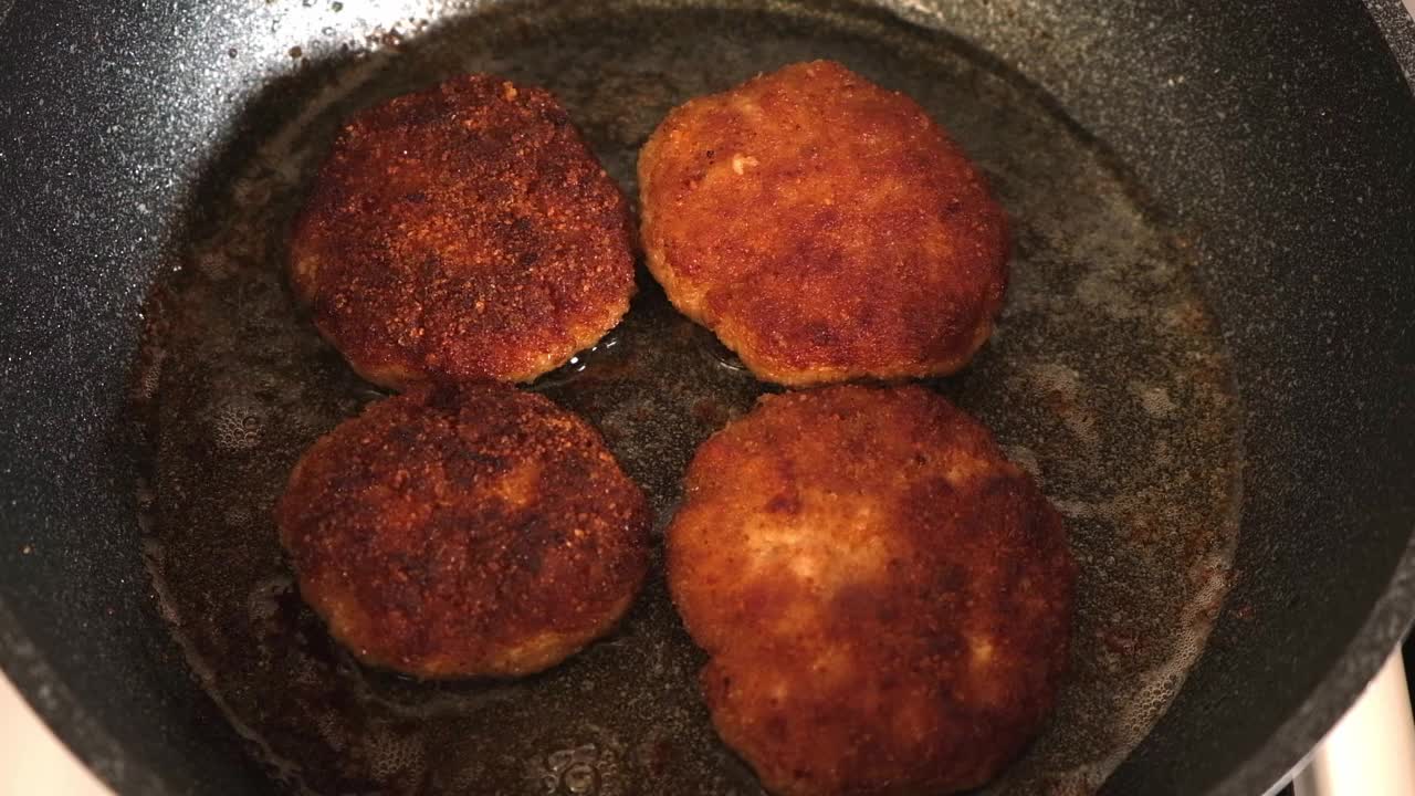 葵花籽油在煎锅里煮，配上自制肉饼。肉排在煎锅里煎。视频素材