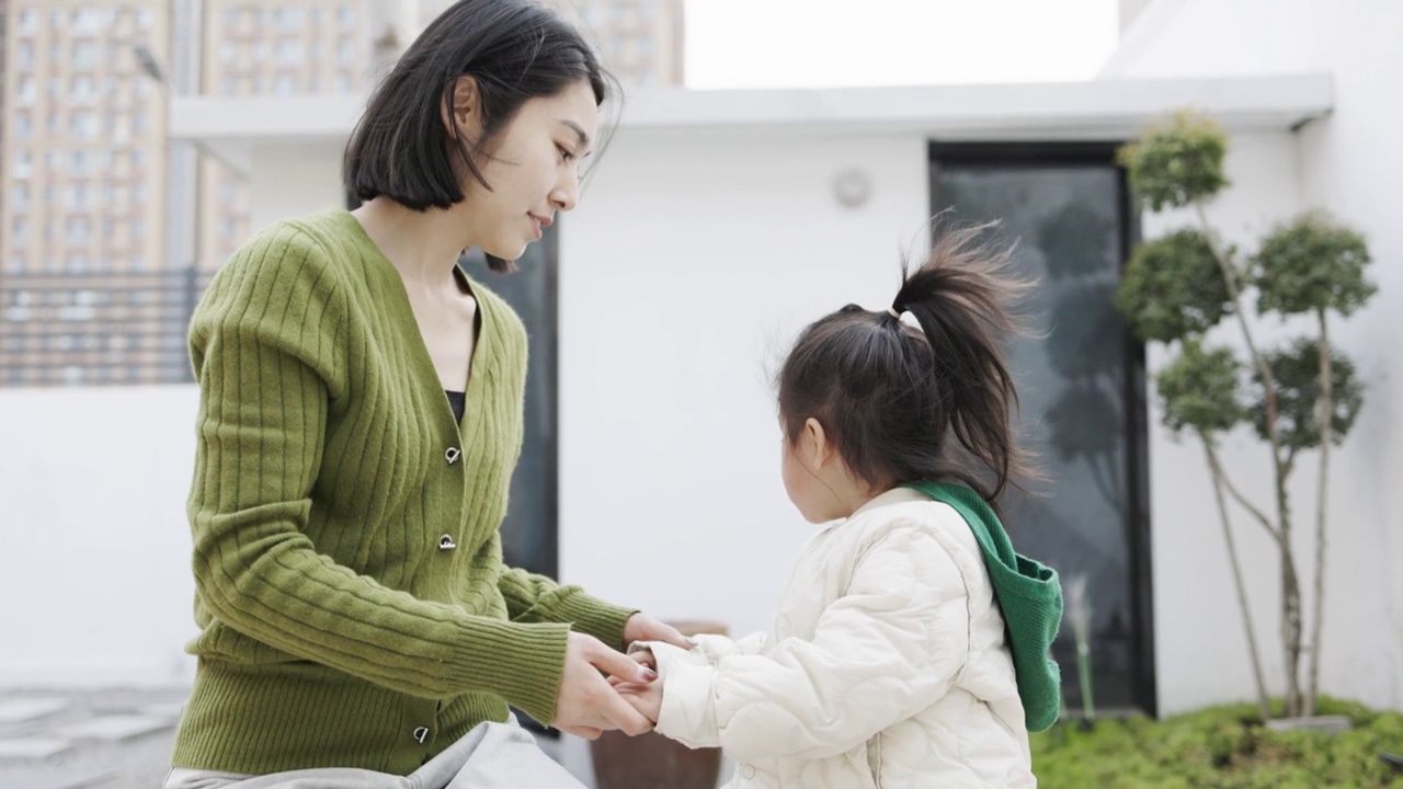 一位年轻的母亲和女儿在院子里玩耍视频素材