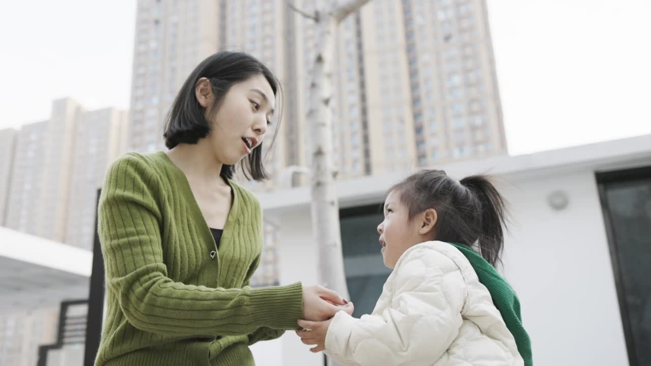 一位年轻的母亲和女儿在院子里玩耍视频素材