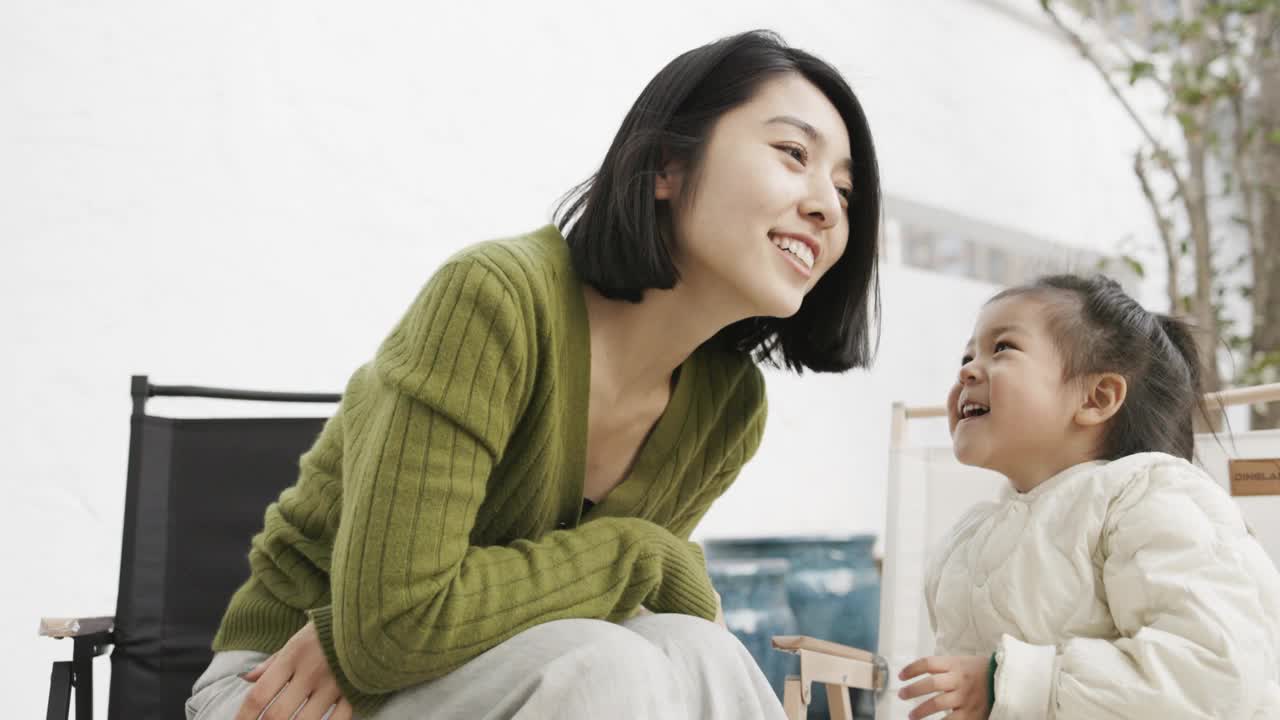 一位年轻的母亲和女儿在院子里玩耍视频素材