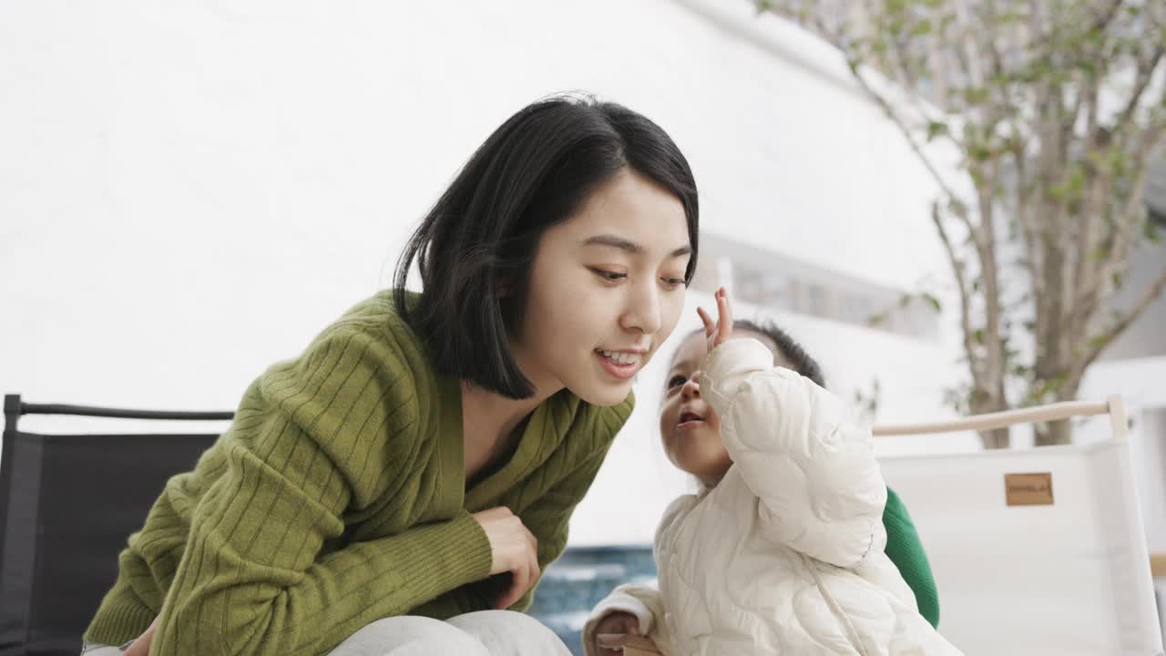 一位年轻的母亲和女儿在院子里玩耍视频素材