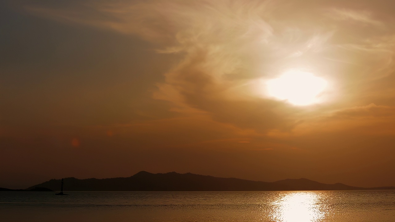 海上的夕阳。背景是山脉。视频下载