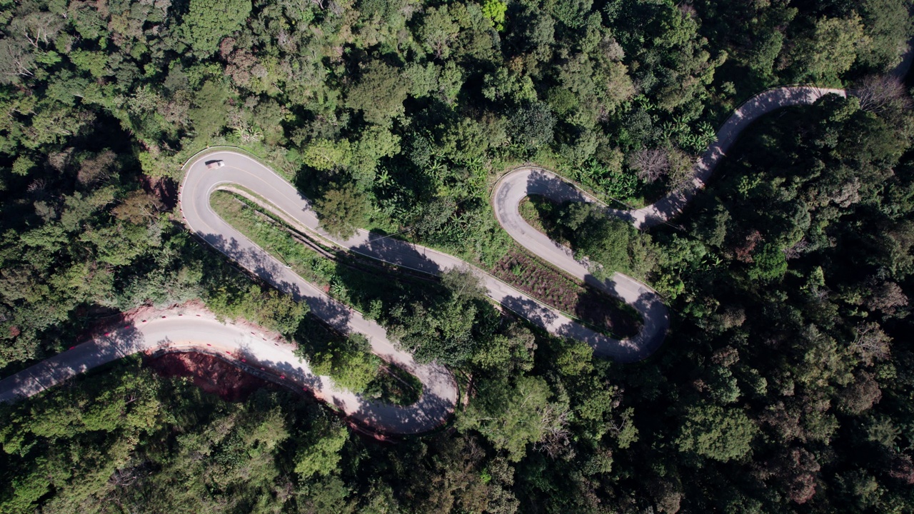 乡村道路的俯视图，穿过绿色的森林和山视频素材