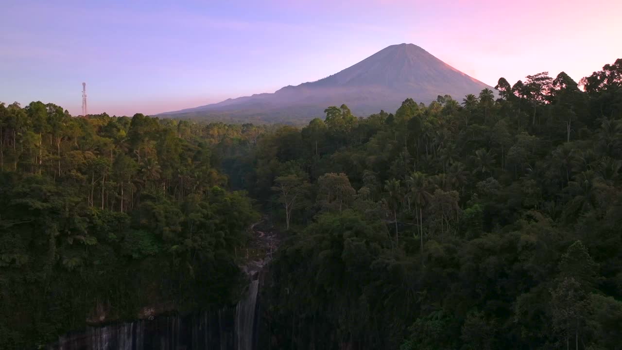 风景秀丽的鸟瞰图日出的图姆帕克塞乌瀑布与塞默鲁火山背景丛林在爪哇岛，印度尼西亚视频素材