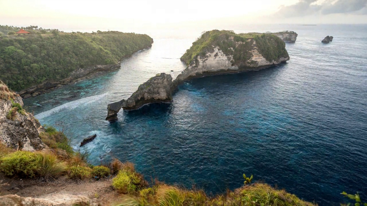 印度尼西亚巴厘岛努沙佩尼达的延时日出场景-阿图海滩-清澈的蓝色海水与白色岩石悬崖-热门旅游目的地美丽的自然景观视频素材