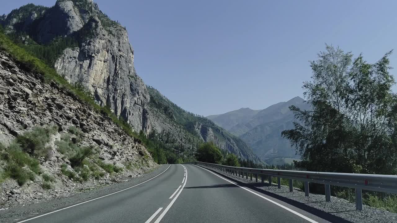 汽车行驶在山路上，景色壮丽。开车旅行。美丽的大自然。视频素材