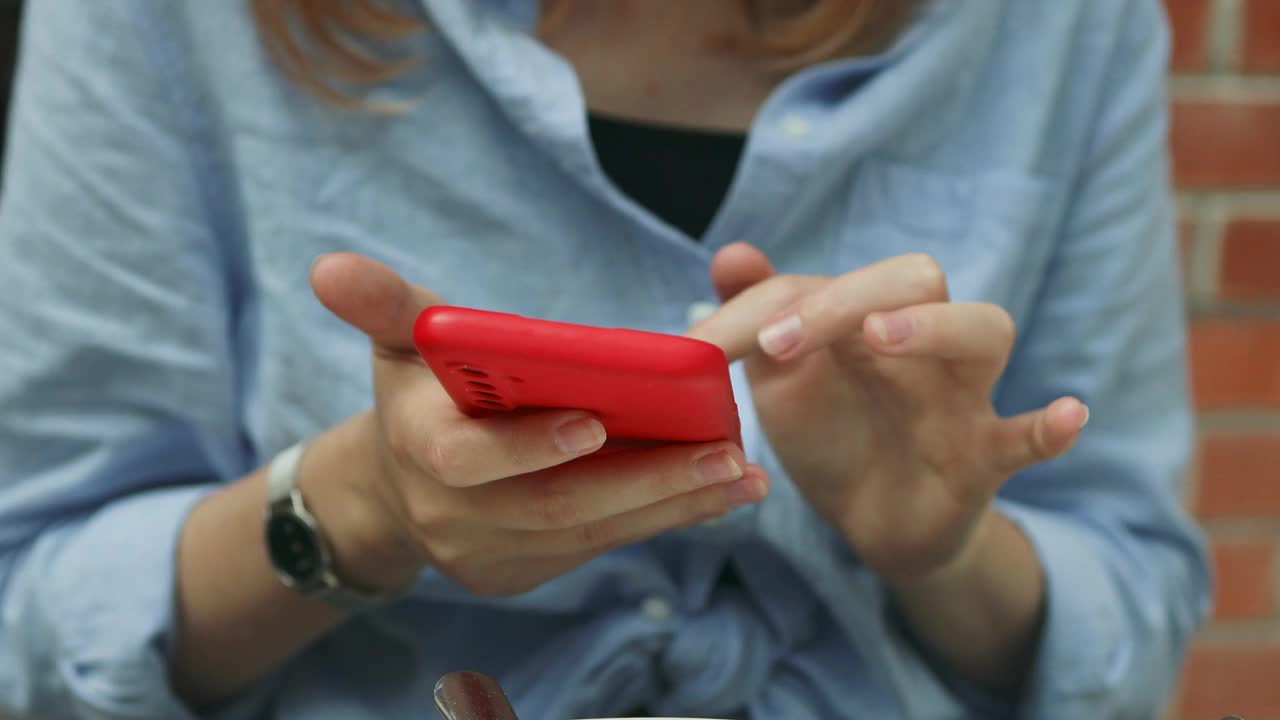 女人用手机发短信或聊天的手。女人手的特写。视频素材