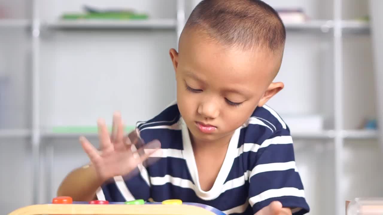 一个男孩在屋子里的桌子上玩发育玩具。视频素材