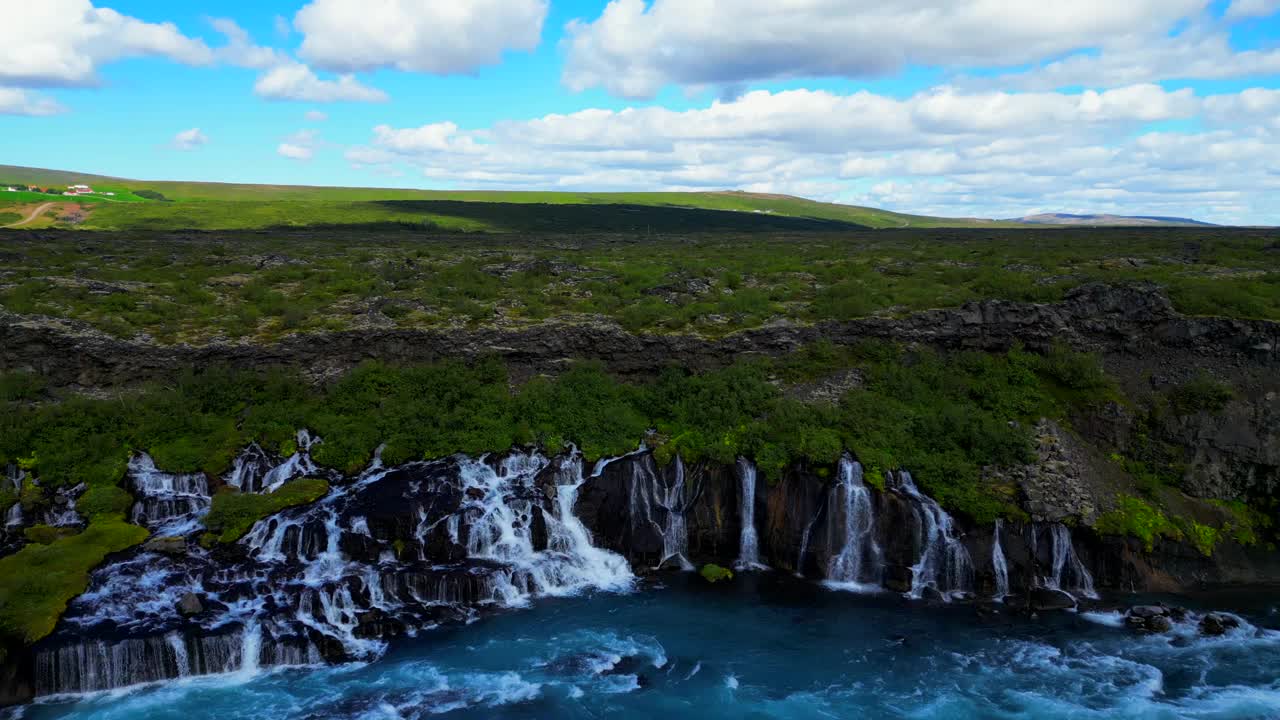 冰岛Hraunfossar瀑布与绿色山丘的鸟瞰图视频素材