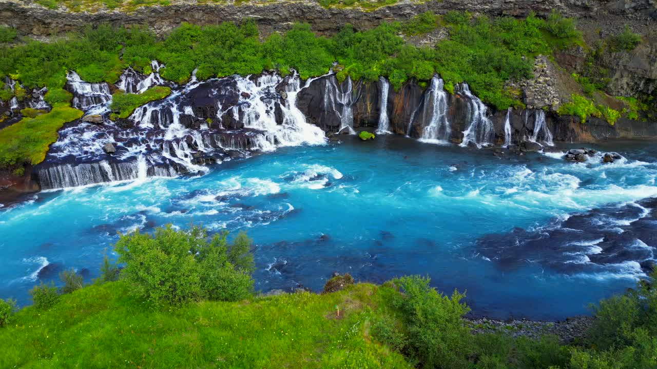 冰岛Hraunfossar瀑布与绿色山丘的景观场景视频素材