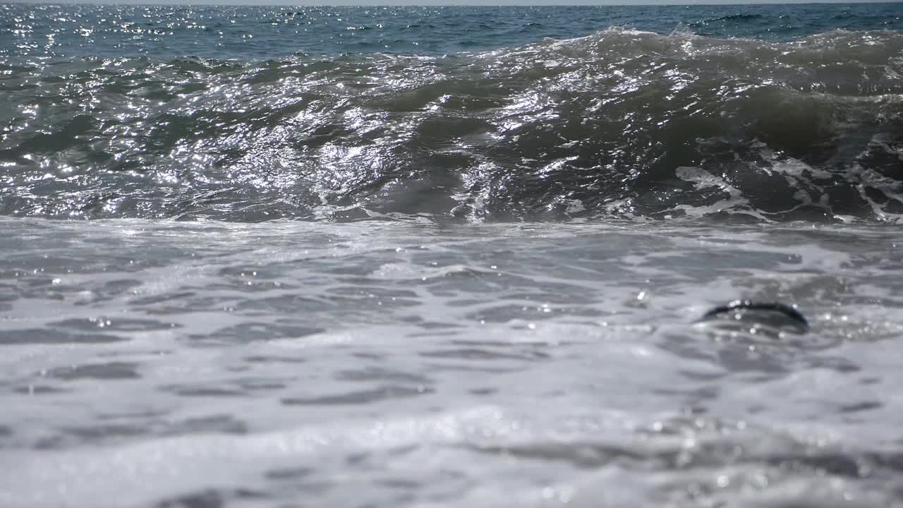 巨大的海浪在岸边的鹅卵石上击碎泡沫的惊人景色。视频素材