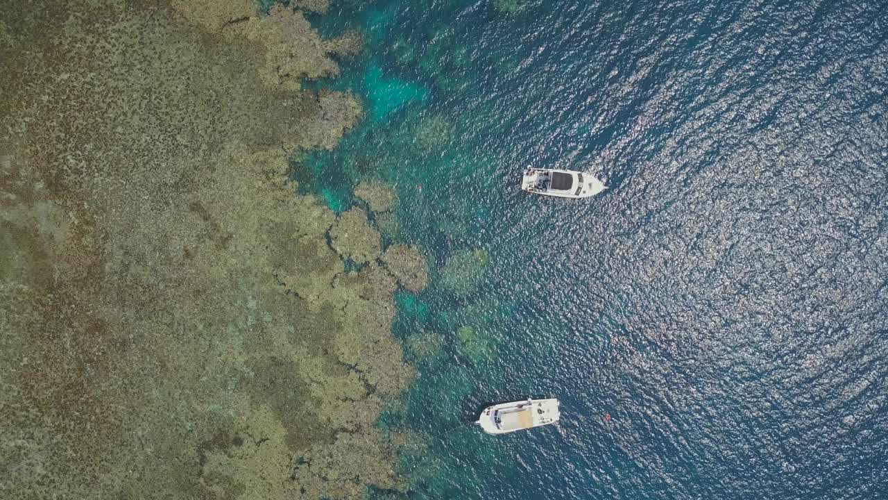 两艘船在吉达附近的一个暗礁岛上的红海无人机视图视频素材