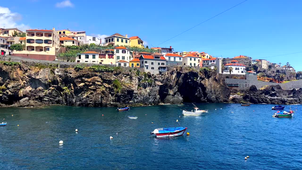 葡萄牙马德拉岛，卡马拉德洛沃斯港湾湾，充满活力的房屋和船只视频下载