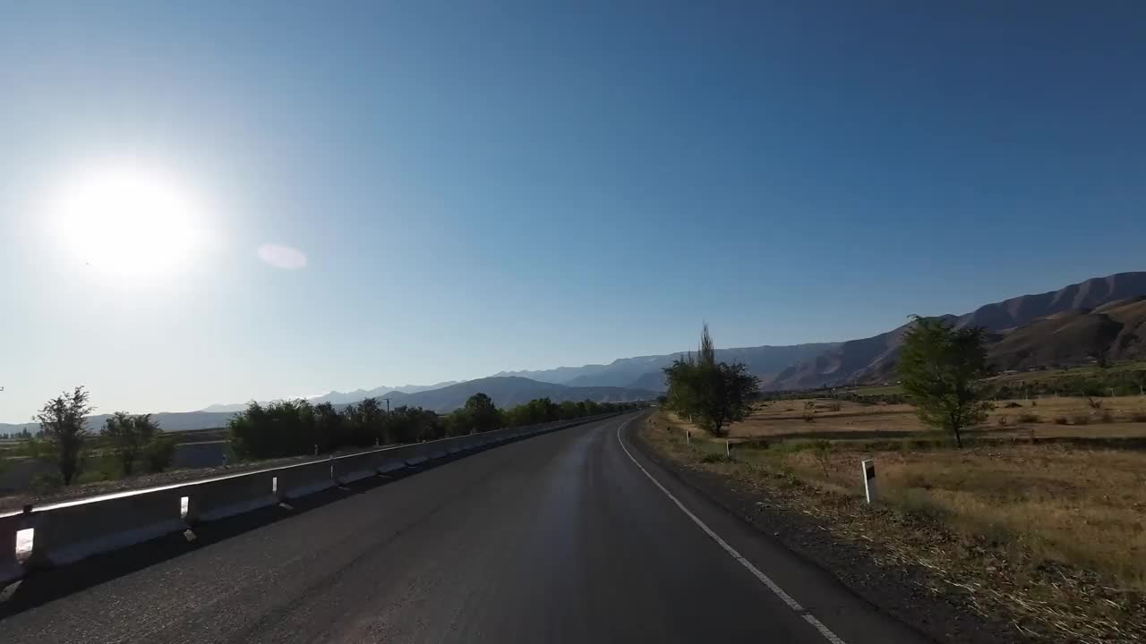 行驶在柏油路上，穿过宽阔的山峡。汽车的观点视频素材