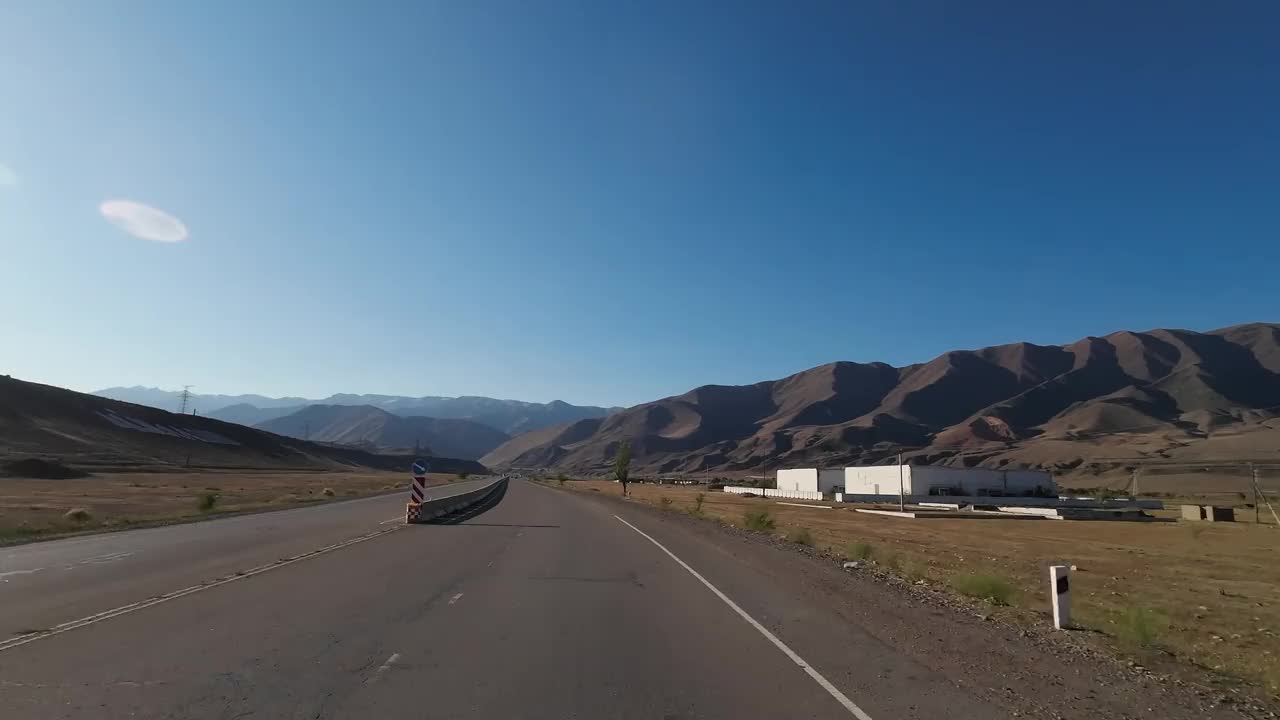 行驶在柏油路上，穿过宽阔的山峡。汽车的观点视频素材