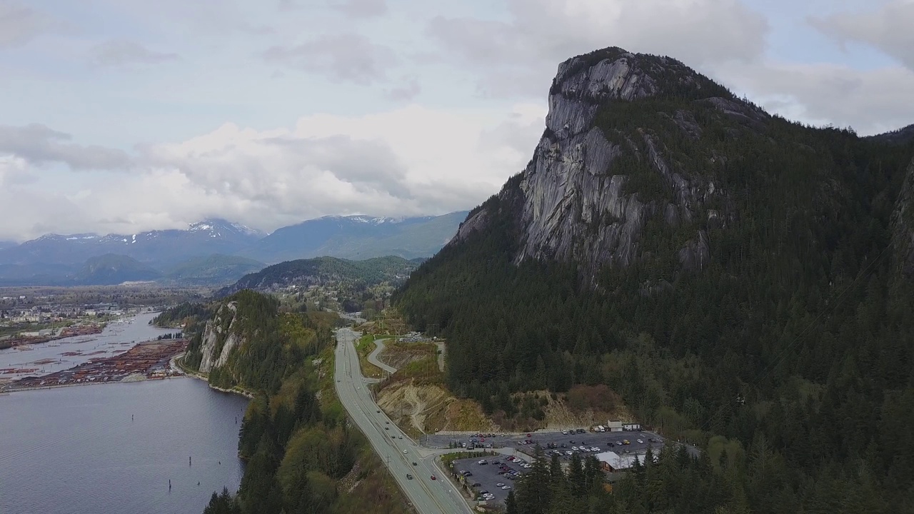 海天高速公路上的航拍镜头，背景是酋长山和斯夸米什市。摄于加拿大不列颠哥伦比亚省一个多云的夜晚视频素材