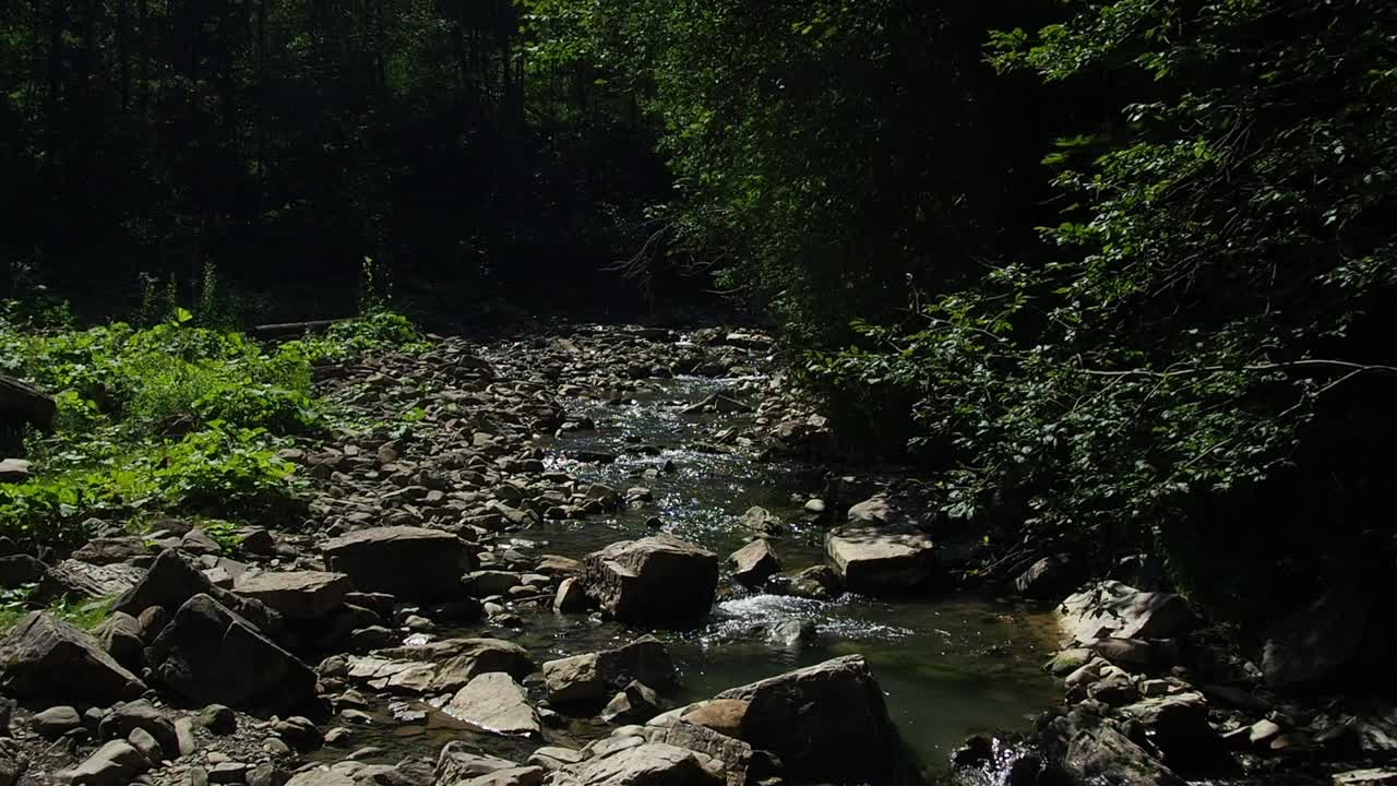 小河湍急而生动地流过它荒凉的石谷视频素材