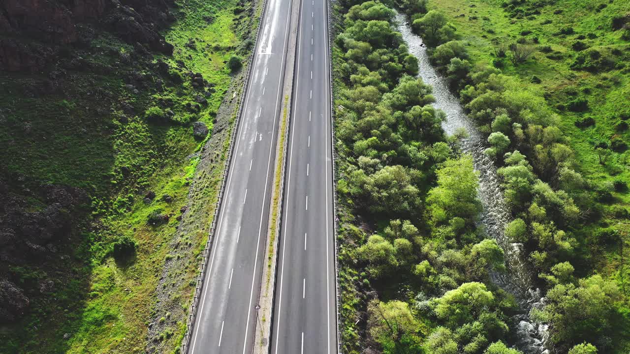 山地绿林地区多车道高速公路4K航拍图视频素材