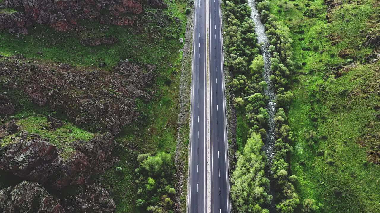 山地绿林地区多车道高速公路4K航拍图视频素材