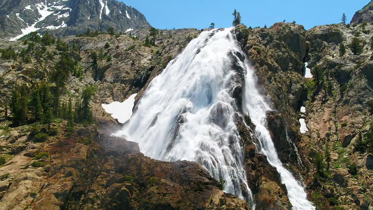 空中倾斜向下拍摄的风景瀑布在山上，无人机飞越景观在阳光明媚的日子-猛犸湖，加利福尼亚视频素材