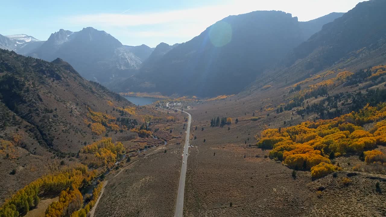 空中向前拍摄的车辆在道路上通过山脉，无人机飞越风景秀丽的风景-猛犸湖，加利福尼亚视频素材