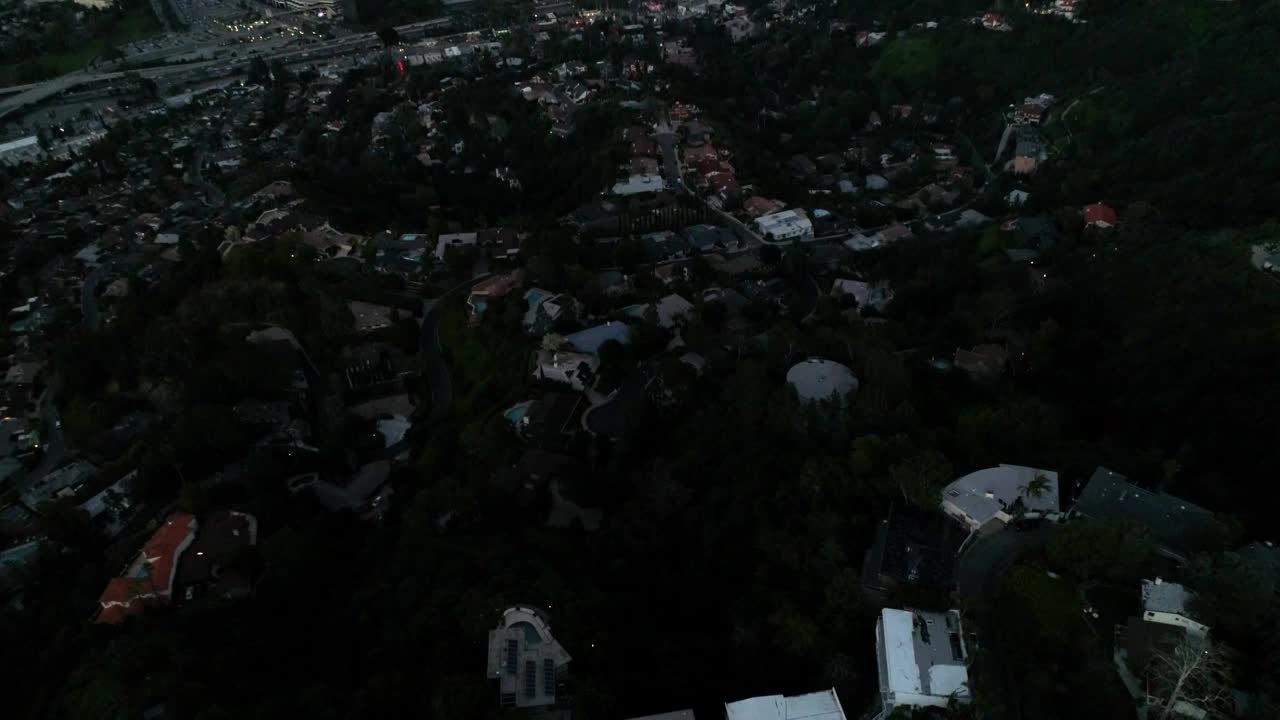 空中向后倾斜拍摄的房子在附近的山对天空在日落-洛杉矶，加利福尼亚视频素材