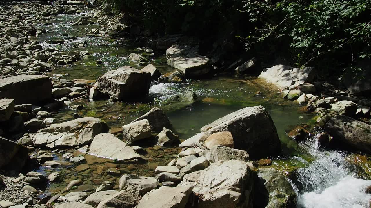 小河湍急而生动地流过它荒凉的石谷视频素材