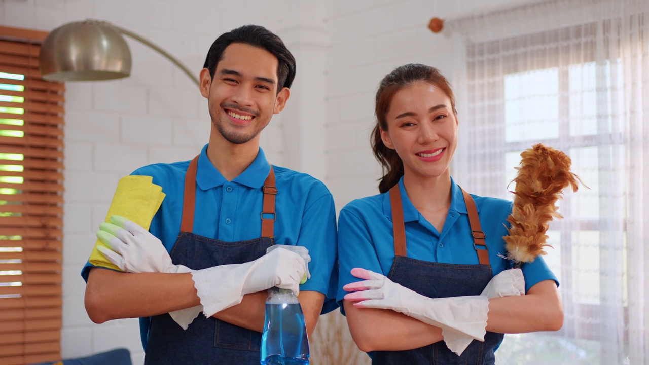 年轻男女清洁服务工人在房子里工作的肖像。有吸引力的管家清洁团队穿着围裙和清洁凌乱肮脏的地板为客房的家务和家务。视频素材