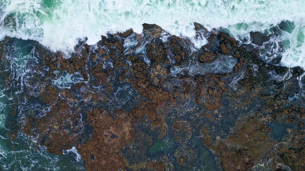 无人机看到暴风雨的海洋海浪撞击火山海滨。泡沫般的海浪拍打着海岸视频素材