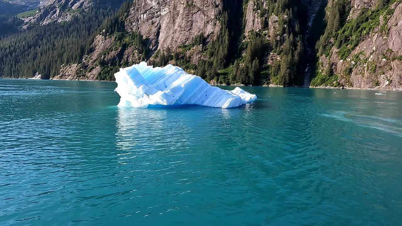 冰山漂浮在水面上。在阳光明媚的日子里，美丽的山海和绿松石般的海水。全球变暖。气候变化。随着全球气候变暖，气温升高使冰川逐渐融化。视频素材