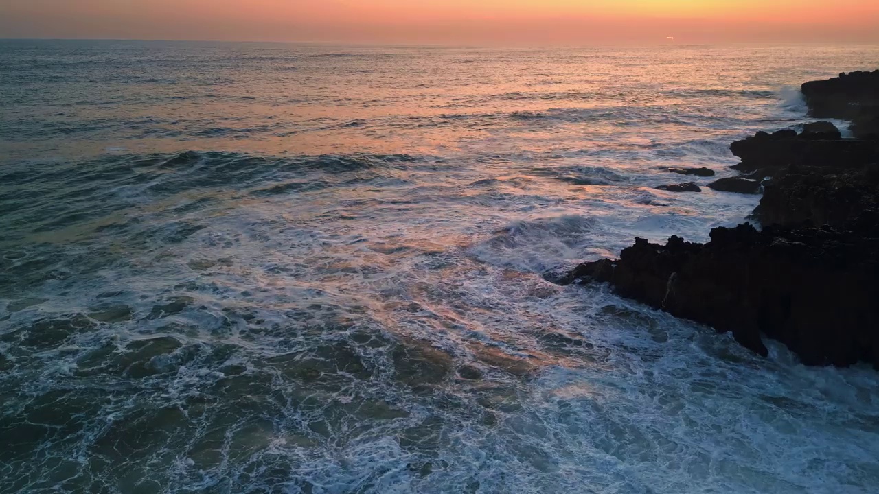 戏剧性的大海发泡海岸线石头日落。波涛汹涌的大海汹涌着岩石视频素材