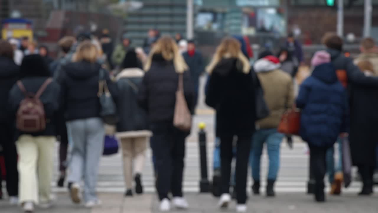 散景模糊的人拥挤步行穿过繁忙的城市街道慢动作，城市生活中，很多行人拥挤人行横道视频素材