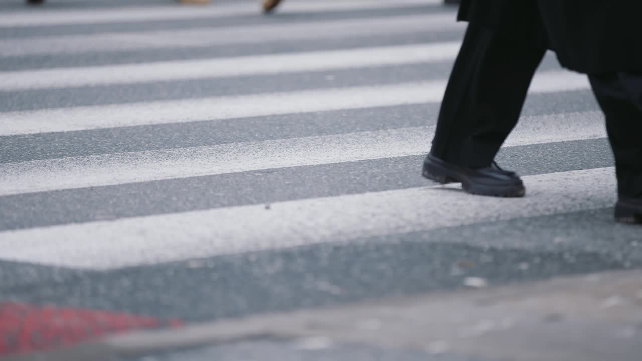 慢动作人群拥挤脚鞋走在繁忙的街道。人行横道上挤满了行人。高峰时段的腿沥青斑马线视频素材