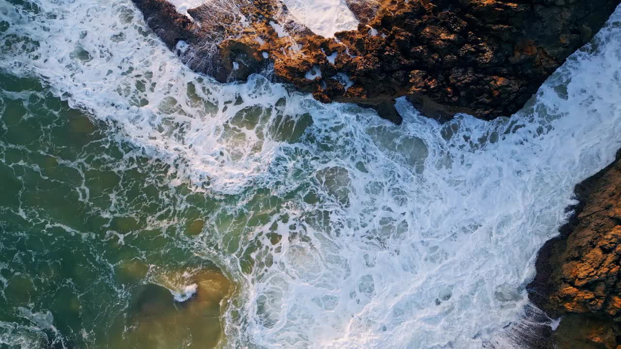 强大的海浪冲击海岸岩石特写。汹涌的海水飞溅视频素材