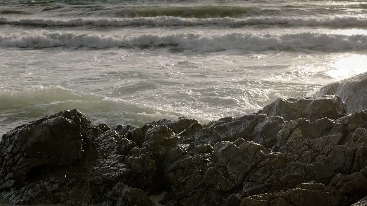 日落时海浪冲击着岩石。采购产品日落，波浪，岩石，海洋，海景，海岸，水，海岸线，地平线，海，戏剧性，风景，自然，海岸风景，大气，戏剧性视频下载