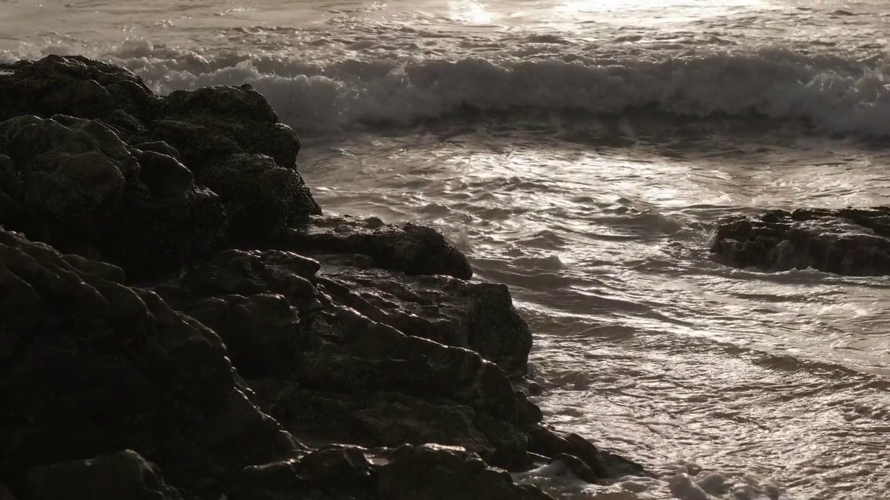 日落时海浪冲击着岩石。采购产品日落，波浪，岩石，海洋，海景，海岸，水，海岸线，地平线，海，戏剧性，风景，自然，海岸风景，大气，戏剧性视频素材