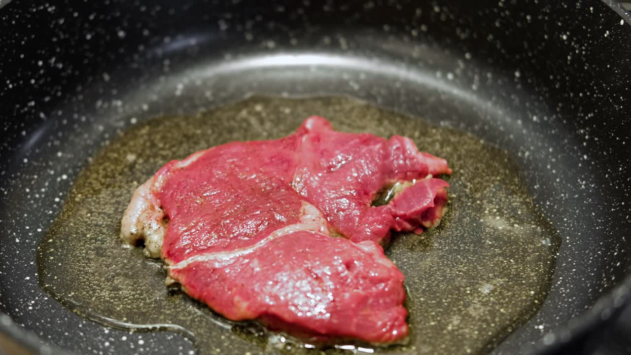 用香草黄油、胡椒和迷迭香煎牛肉片。煎肉排。特写镜头。煎牛眼肋排。菲力牛排。制作原味安格斯肋眼。食物配方背景视频素材