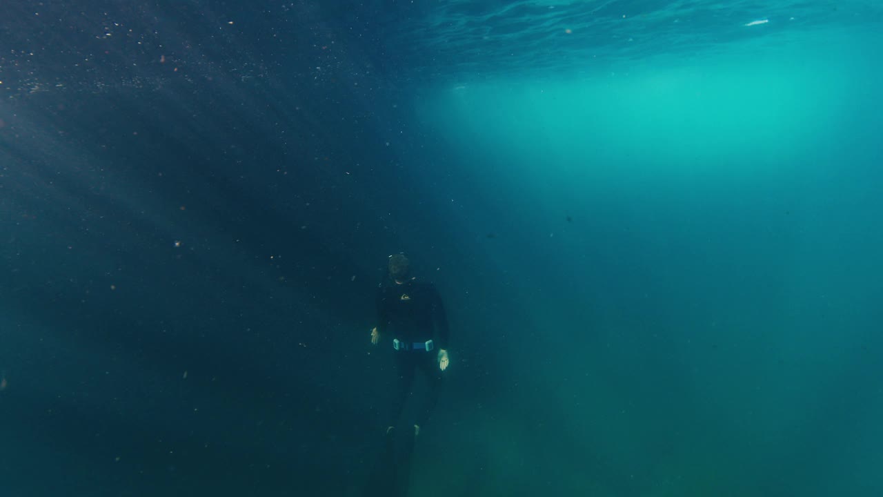 自由潜水员在浑浊的海水中游泳，然后上升。在海洋中自由潜水视频素材