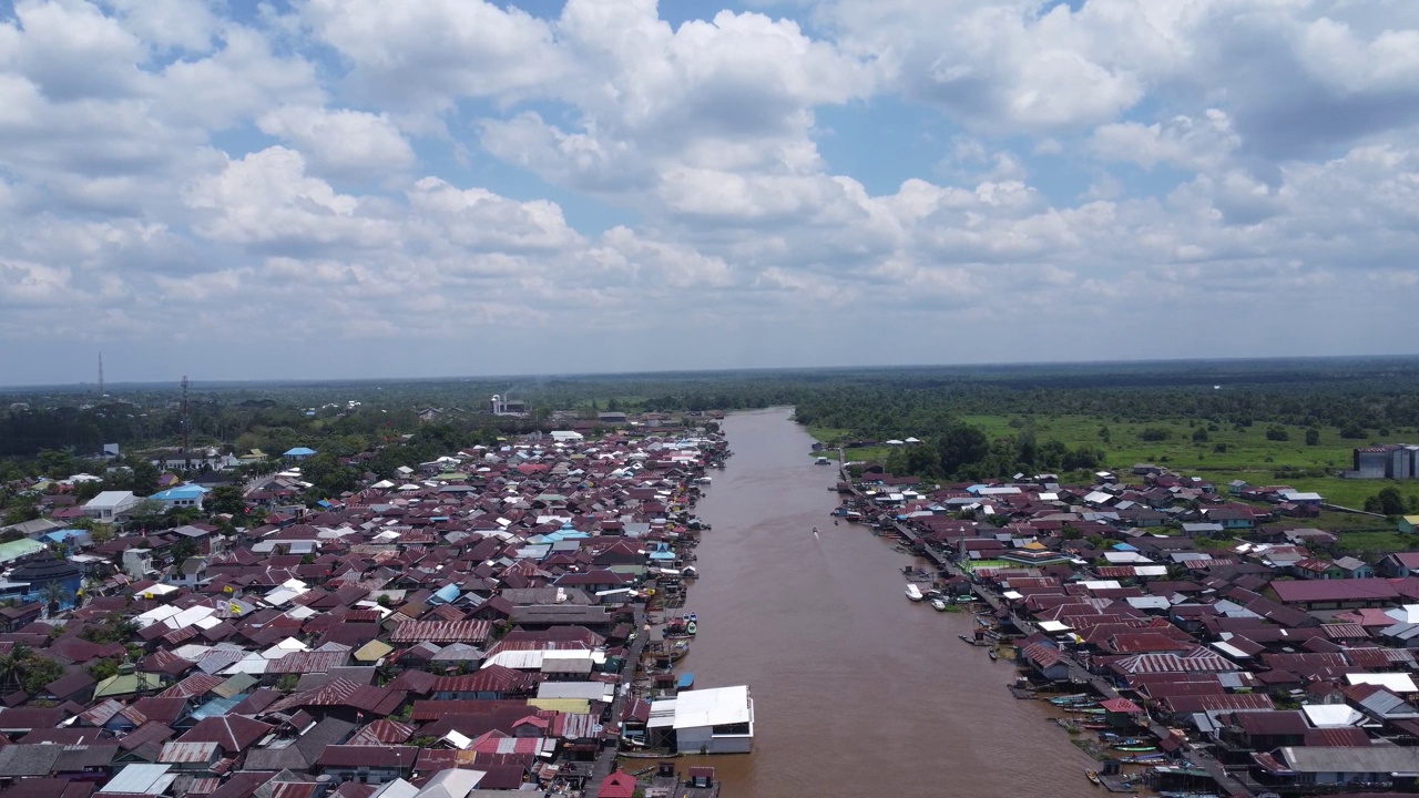 城市在河岸上的鸟瞰图，船只在河上飞驰。Pangkalan Bun，加里曼丹中部，印度尼西亚- 2023年8月25日视频素材