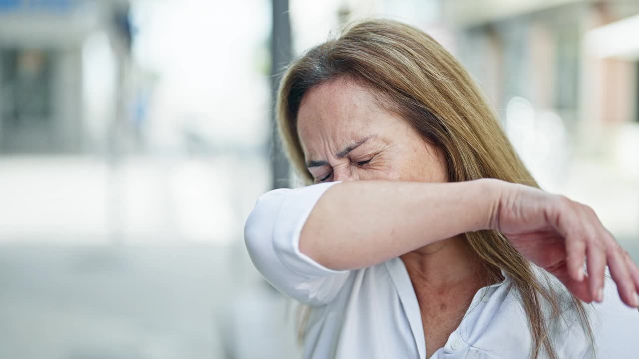 中年西班牙妇女在街上打喷嚏视频素材