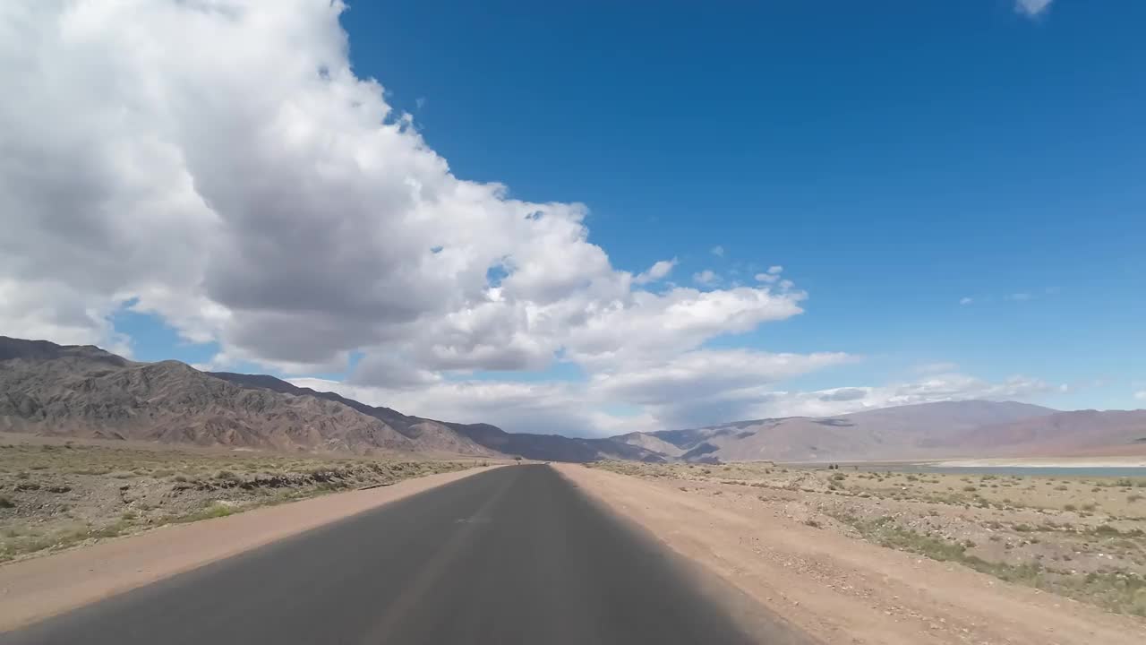 行驶在刚刚覆盖的公路上的山湖。汽车的观点视频素材