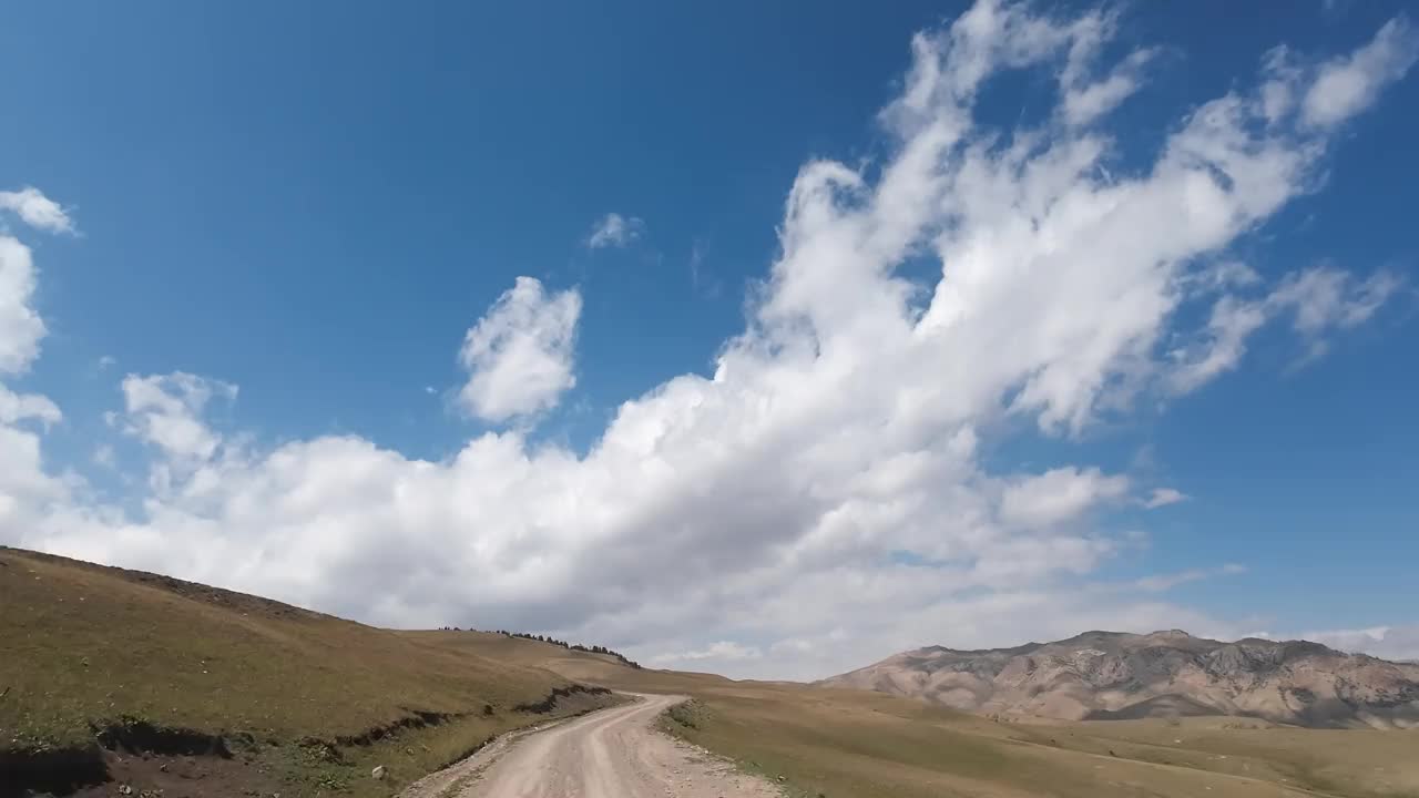 在崎岖的土路上开车到山口。汽车的观点视频素材