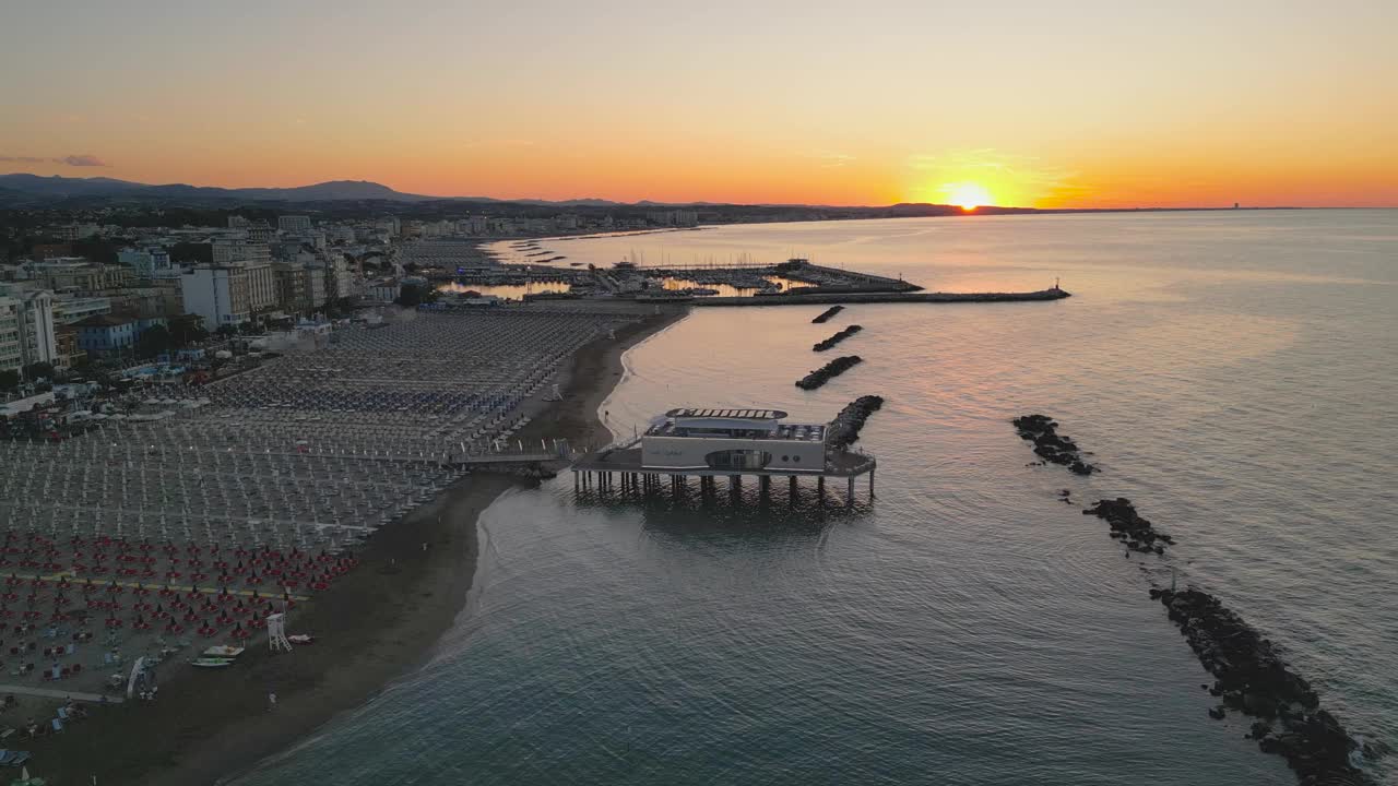 一架无人机升起，展现了意大利日落时分罗马涅里维埃拉的海岸和大海视频素材