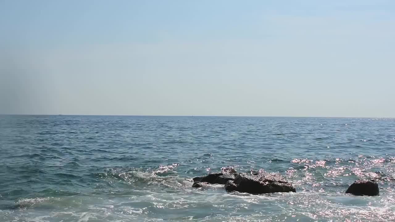 海浪拍打着岩石。海浪冲击着岩石海滩。视频素材