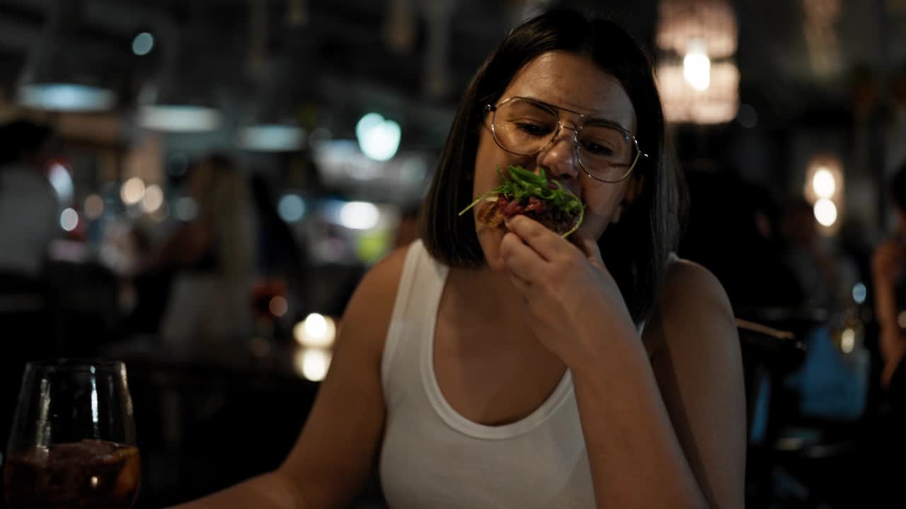 年轻漂亮的西班牙女人在餐厅吃美味的意大利菜视频素材