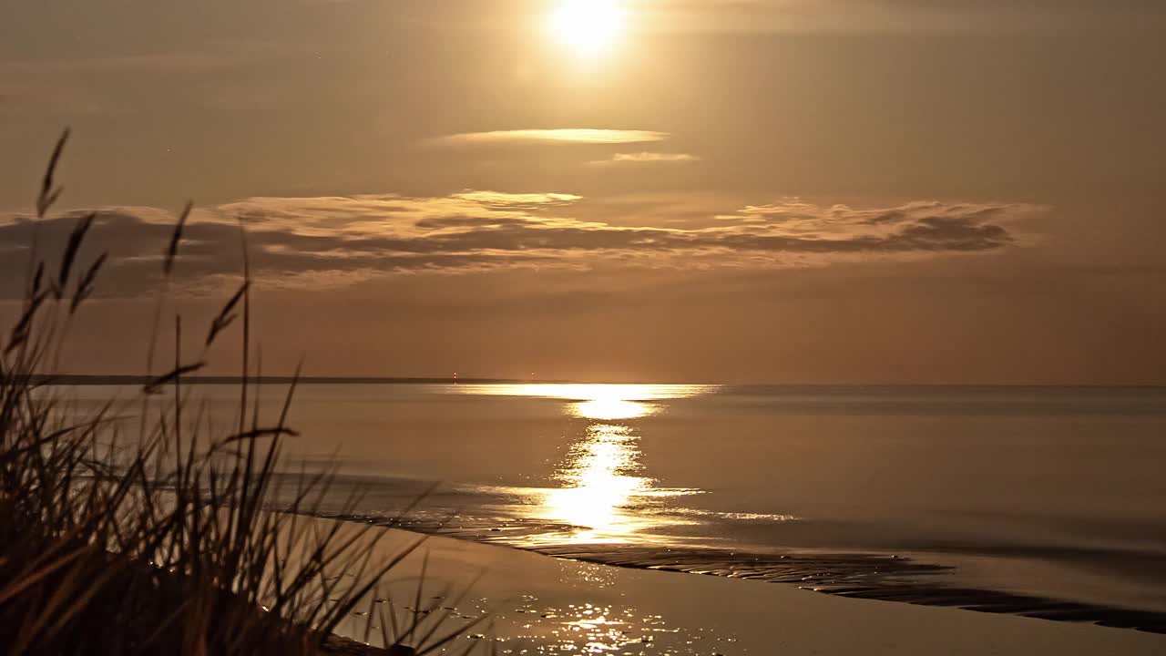 太阳从海洋的地平线上落下，晚上有云经过的时间差。视频素材