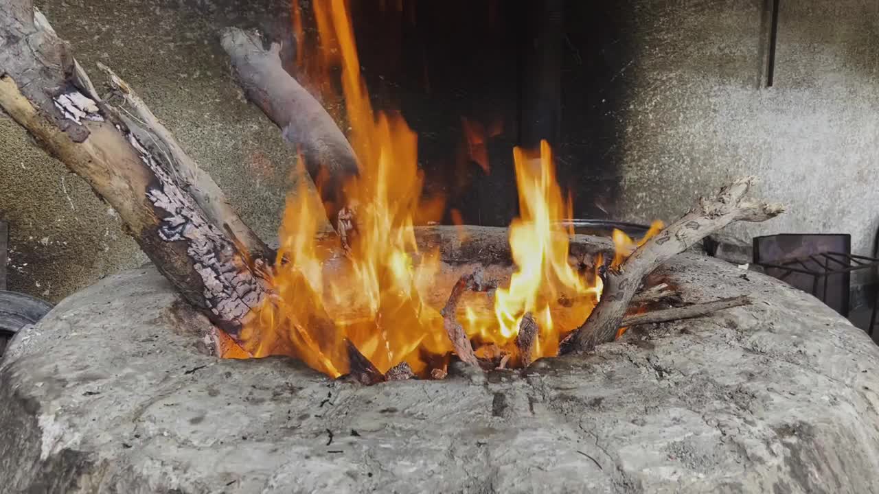 在火炉里烧柴。准备煮肉的炉膛。在户外烧烤。视频素材