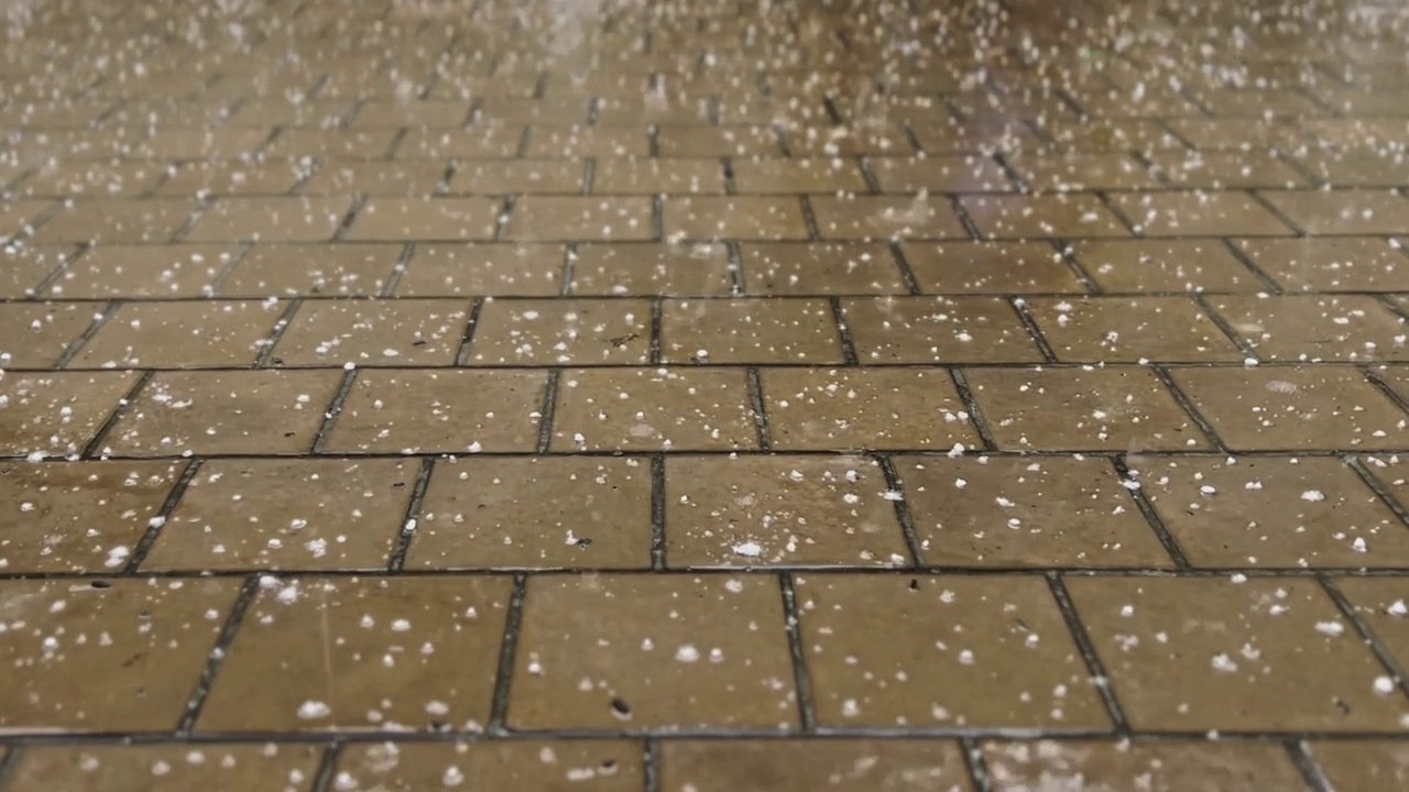 夹杂着冰雹的大雨点落在石板上。视频素材