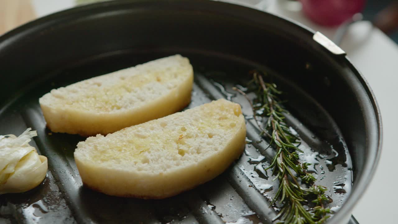 在烤盘上用香草和大蒜煎法棍片视频素材